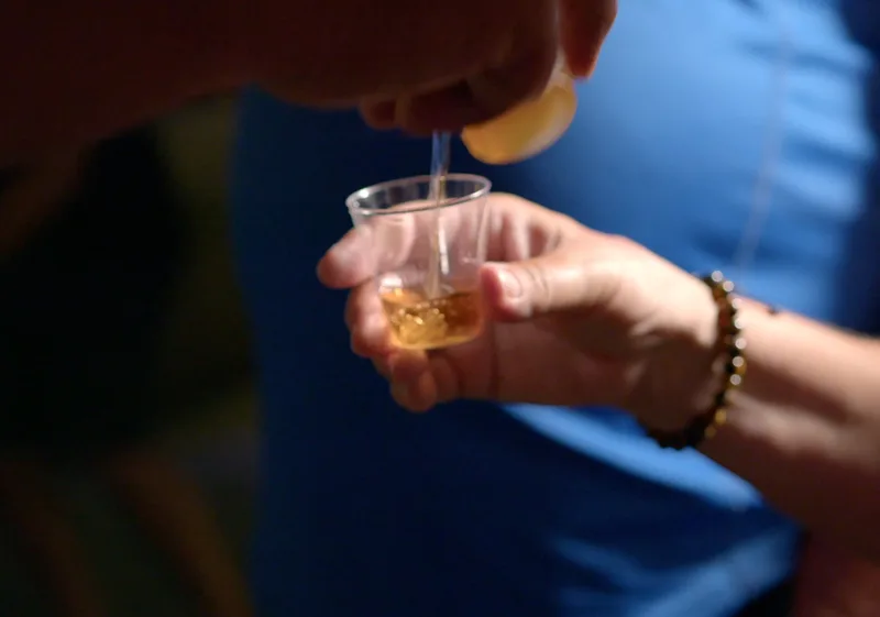 Pouring drink into a class at Macorix house of rum